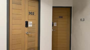 Deux portes en bois portant les numéros 302 et 306, et une enseigne indiquant « 3e étage ».