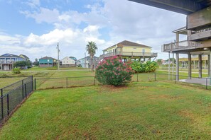 Área residencial com casas, quintal cercado e céu claro.