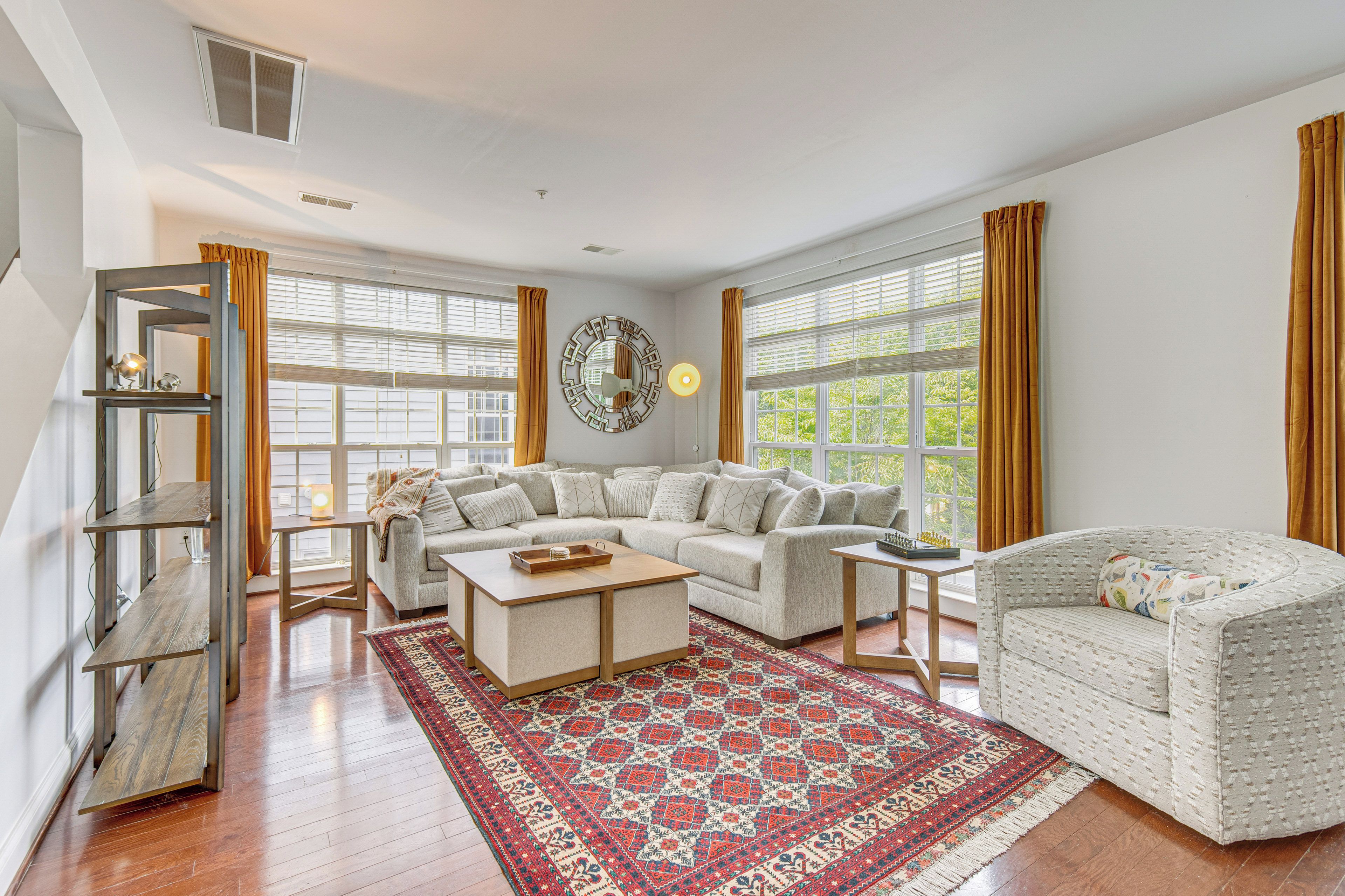 A spacious living room with a large sofa, a coffee table, and a patterned rug.