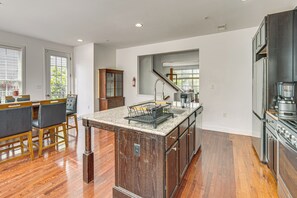 Een moderne keuken met een centraal eiland, houten keukenkastjes en een roestvrijstalen afzuigkap.