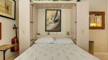 Een slaapkamer met een bed, een gitaar, een lijst met een schilderij en een spiegel.