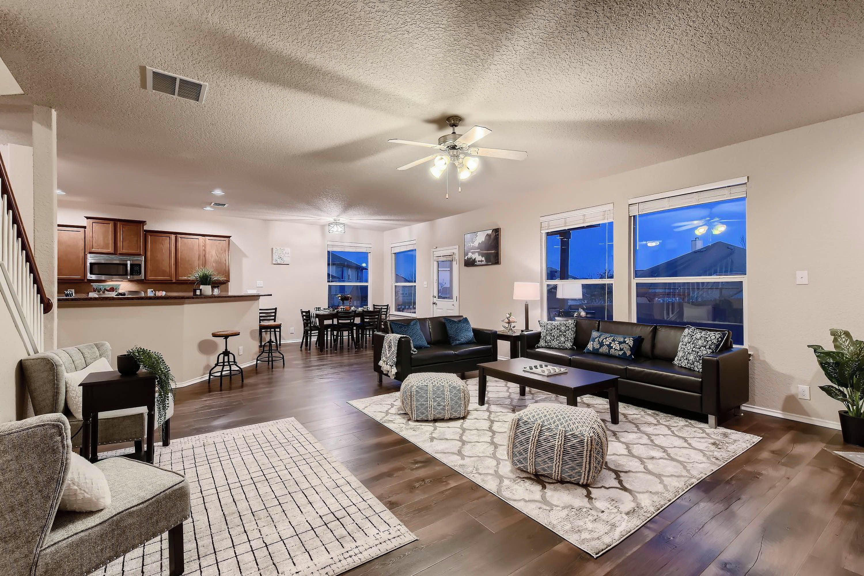 A spacious living room with a fireplace, a dining area, and a kitchen.