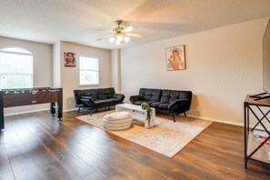 A living room with a pool table, two black leather sofas, a coffee table, and a ceiling fan. - 7 Mi to SeaWorld! Group-Friendly Getaway w/ Pool (San Antonio)