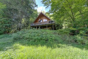 Eine Hütte mit Balkon, umgeben von dichtem Wald.