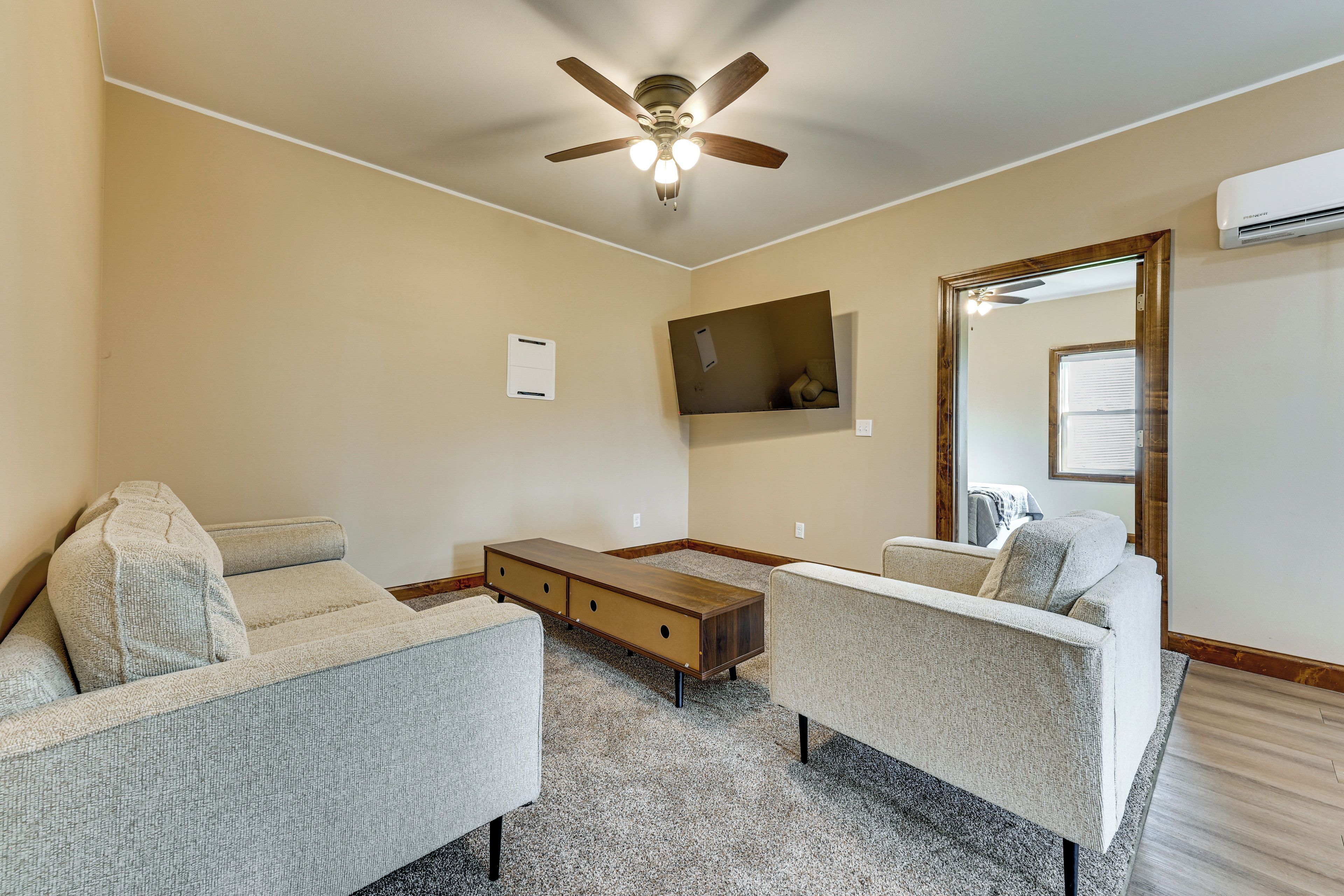 A living room with two sofas, a coffee table, and a ceiling fan.