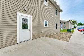 A residential building with a white door, a small window, and a parking sign indicating a disabled parking space.