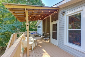 A wooden deck with a pergola, outdoor seating, and string lights. - Gaston Lake House: Dock, Deck, Game Room! (Bracey)