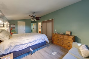 A bedroom with a bed, dresser, and a ceiling fan. - Gaston Lake House: Dock, Deck, Game Room! (Bracey)