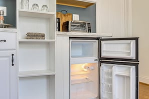 Eine Küche mit einem eingebauten, doppeltürigen Kühlschrank, einer Arbeitsplatte und einem Regal darüber.
