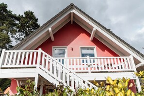 A red building with a white balcony and a small window. - A gorgeous vacation apartment with a sauna and fireplace near the beach in Röbel Müritz (Röbel/ Müritz)