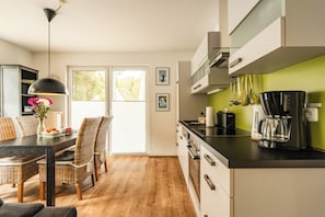 Ett modernt kök med en matplats, komplett med ett matbord och stolar, en kaffemaskin och utsikt över omgivningarna.