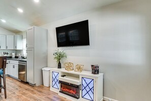 A modern kitchen with white cabinets, a built-in oven, and a fireplace with a glass door. - *New To Market* | Riverfront Pigeon Forge Retreat (Pigeon Forge)