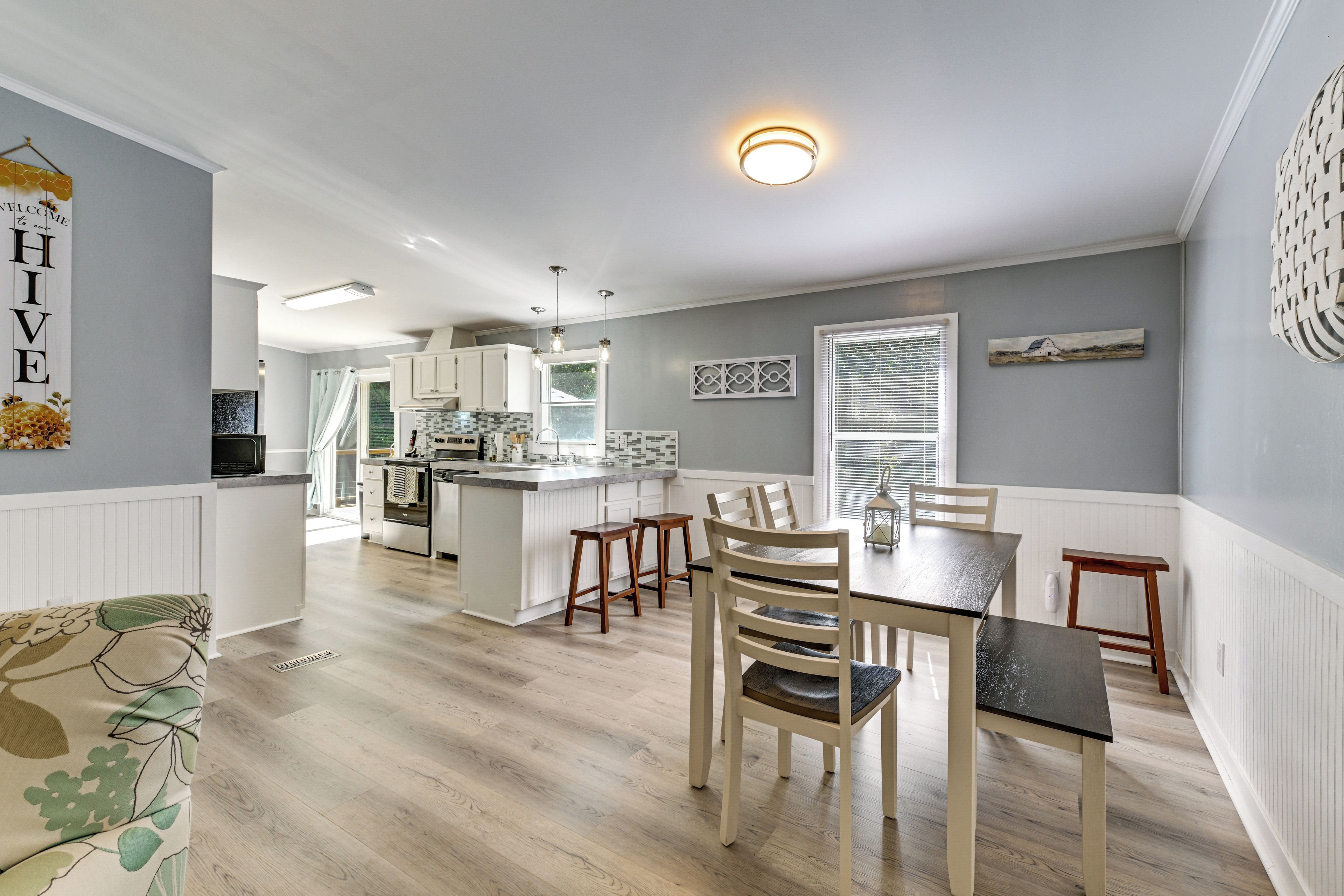 A modern kitchen with white cabinets, a central island, and pendant lighting.