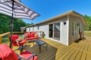 A deck with red furniture and a striped umbrella. - 'Country Retreat' Near Wineries & Wedding Venues (Dobson)