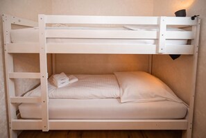 Ein Stockbett mit einem Bett unten und einer Matratze oben.