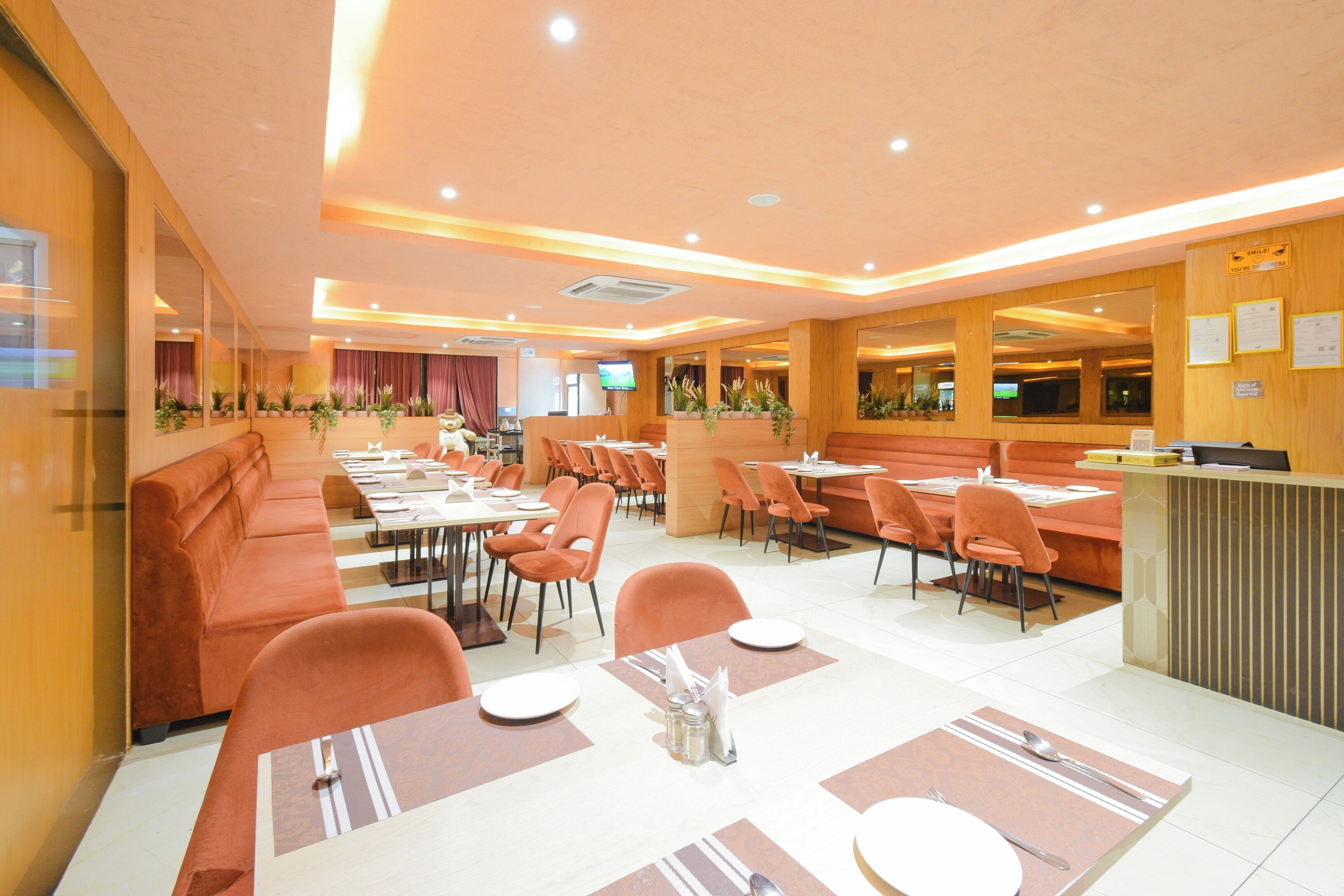 Ein Restaurant mit Sitzboxen, Tischen und einer Theke, sowie einem Fernsehbildschirm.