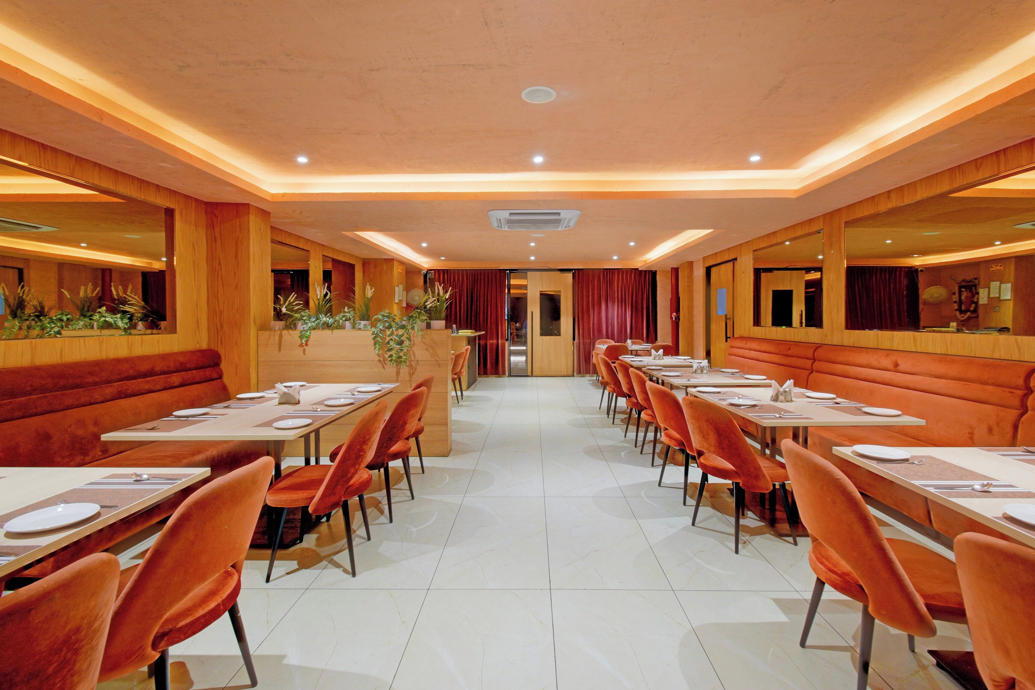 Un restaurante con mesasychairs y cabinas, suelo de baldosas y paneles de madera.