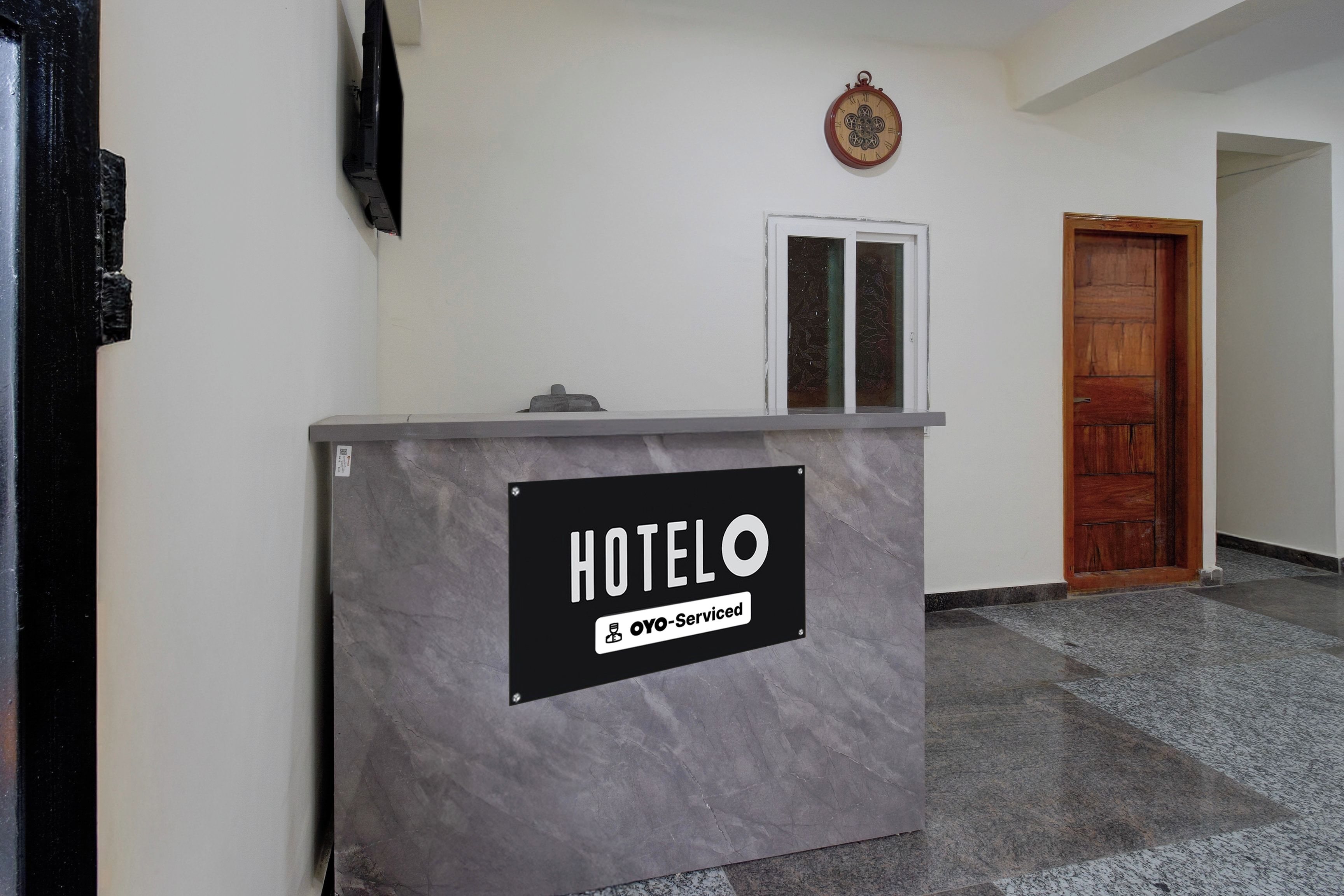 A hotel reception desk with a sign indicating it is serviced by OYO.