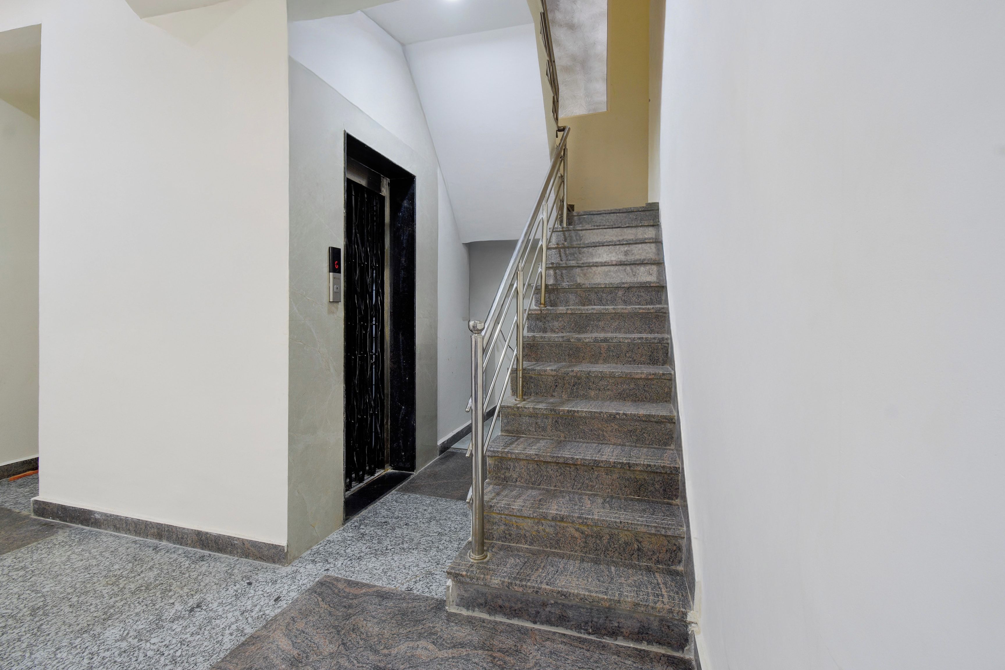 A staircase with a metal handrail leading to a door with a black frame.