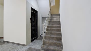 A staircase with a metal handrail leading to a door with a black frame.