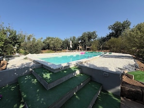 A rectangular swimming pool with a surrounding deck, steps leading into the pool, and a clear sky above. - Beautiful  villa with private pool, A/C, WIFI, TV, patio, pets allowed and panoramic view (Marina Di Ragusa)