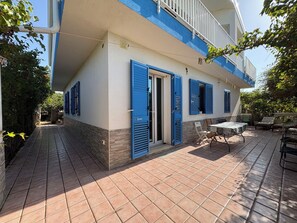 A two-story building with a balcony, a tiled patio, and outdoor furniture. - Beautiful  villa with private pool, A/C, WIFI, TV, patio, pets allowed and panoramic view (Marina Di Ragusa)