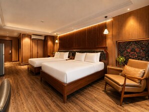 A hotel room with two beds, a wooden floor, a chair, and a wall with a decorative panel. - KAS Sonata Luxury Hotel (Ho Chi Minh)