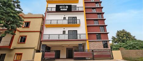 Um hotel com vários andares, com uma placa indicando que é administrado pela OYO.