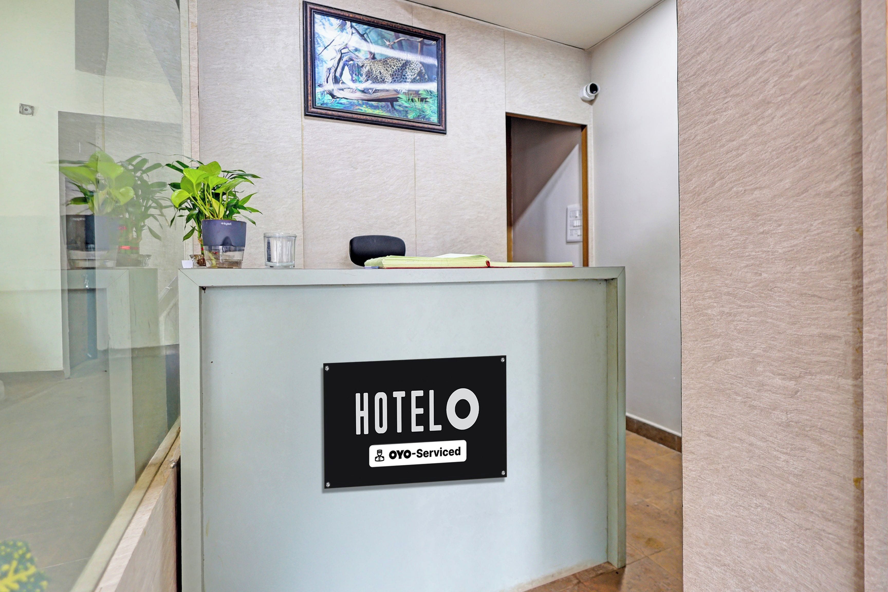 A hotel reception desk with a sign indicating it is serviced by OYO-Serviced.