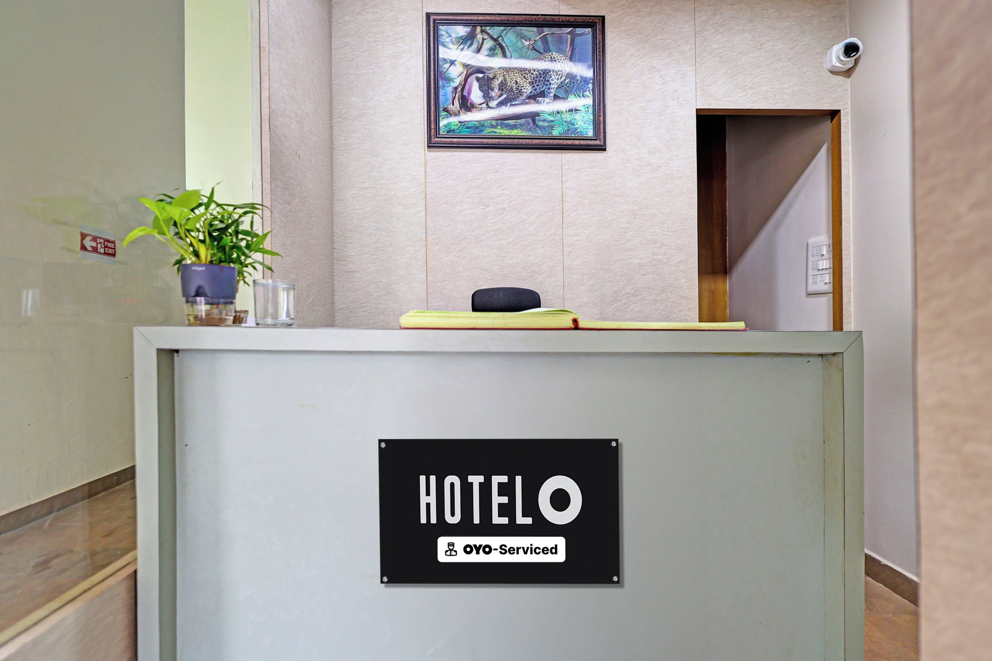 Una reception di hotel con un cartello che riporta 'HOTELO' e 'OYO-Serviced'.
