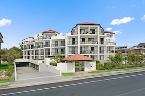 A multi-story hotel with balconies, a covered entrance, and a landscaped garden. - Windsurfer Resort (Gold Coast)