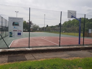 A fenced tennis court with a sign for the Avroch Amenities Association. - Station Hotel (Avoch)