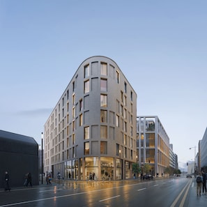 A modern building with a curved facade, large windows, and a ground-level entrance. - Docklands LATROUPE (Dublin)