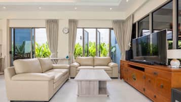 Una sala moderna con un conjunto de sofá, una mesa de centro, un televisor y un mueble.