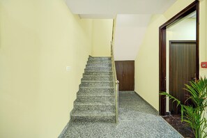 Una escalera con barandilla que lleva a una puerta de madera al final.