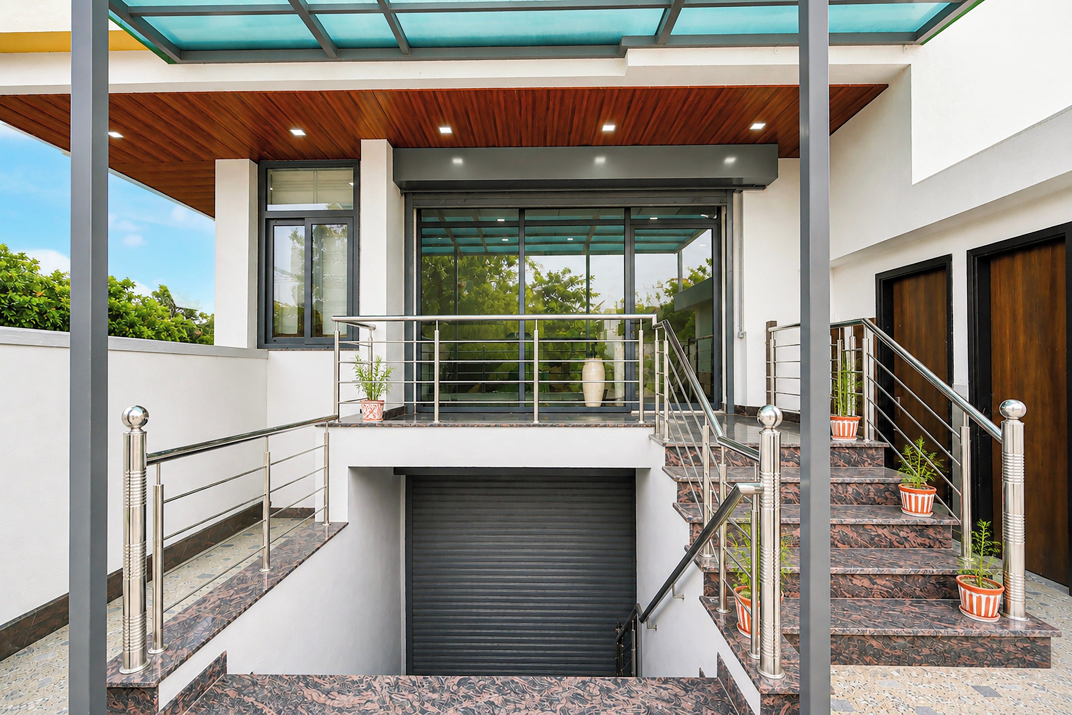 Un edificio moderno con un espacio exterior cubierto, una escalera y un garaje.