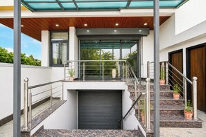 A modern building with a covered outdoor area, a staircase, and a garage. - Palette Mansarover Extension (Jaipur)