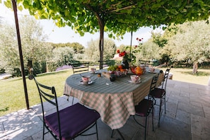 An outdoor dining area with a round table, chairs, and a tablecloth. - Villa 'Maison Lioux Parc Du Luberon' with Private Terrace, Private Garden and Wi-Fi (Lioux)