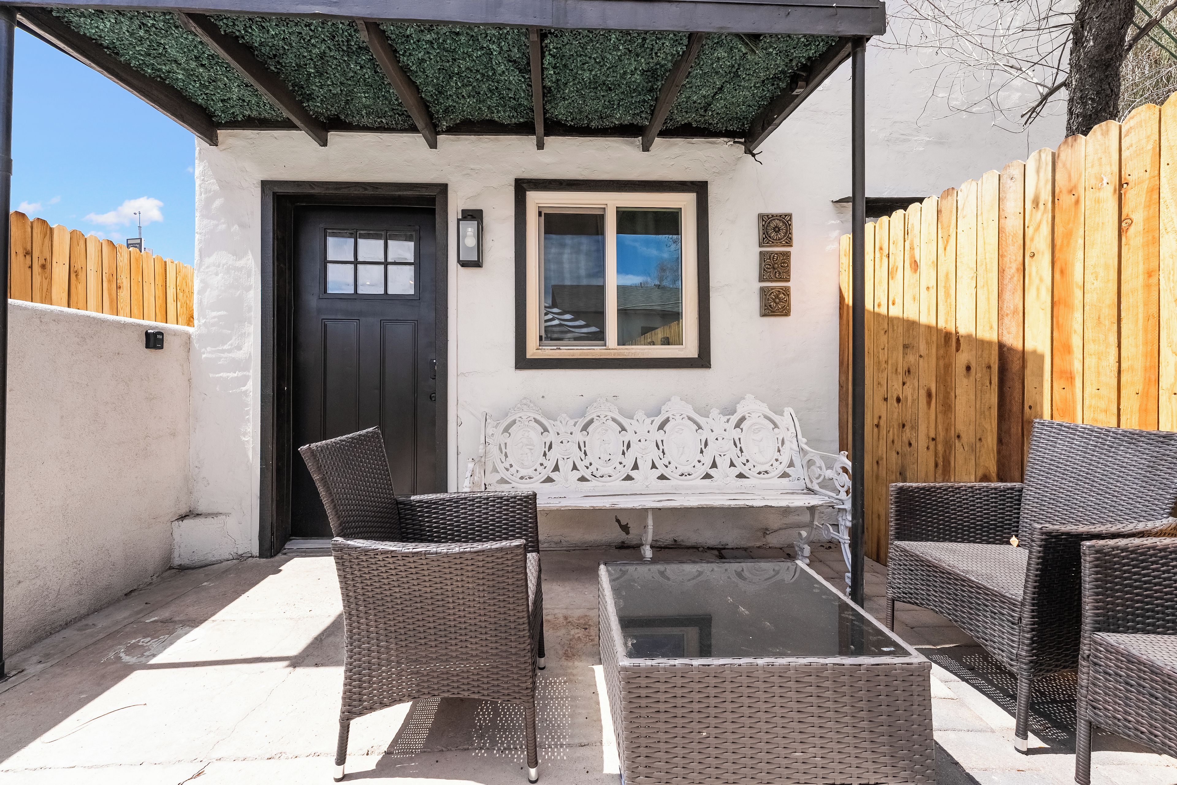 A covered patio with wicker furniture, a door, and a window.