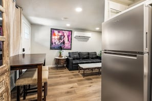 A compact living space with a dining area, a sofa, a coffee table, and a refrigerator. - Prime Dwntwn Location|Fully Private La Casita (Las Vegas)