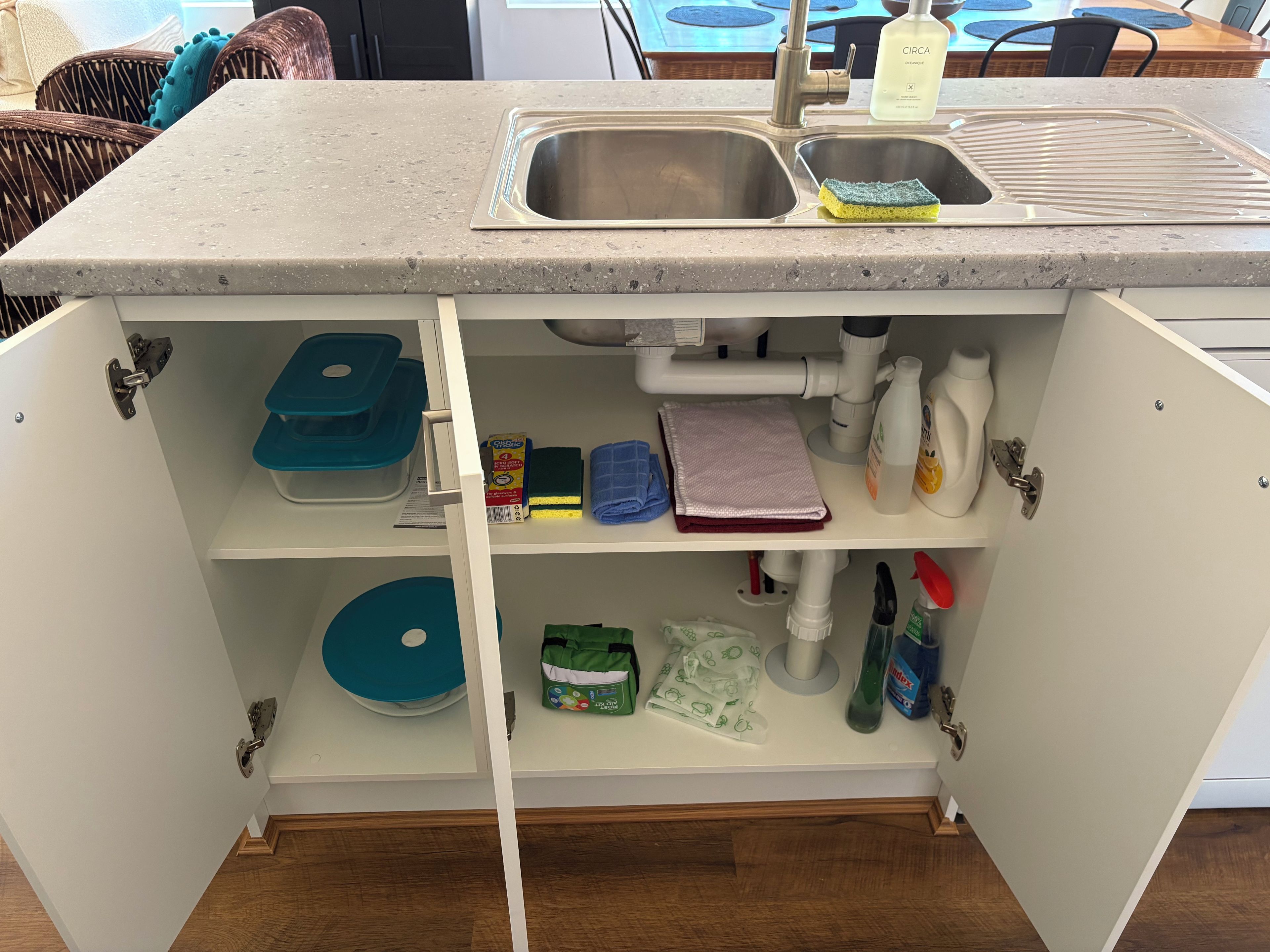 A kitchen with a built-in sink, storage shelves, and a countertop.