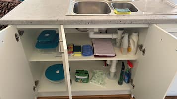 A kitchen with a built-in sink, storage shelves, and a countertop.