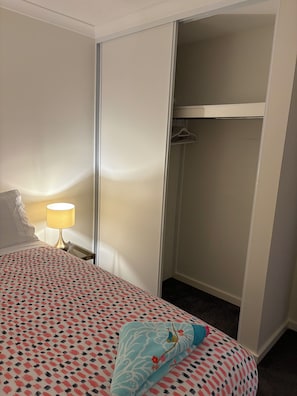 Habitación de hotel con cama, lámpara de noche, armario y ropero.
