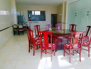 A dining area with a round table and red chairs, a kitchen in the background, and a large wardrobe. - Thank Inn Hotel Hebei Zhangjiakou Wanquan County Kongjiazhuang Bus Station (Zhangjiakou)