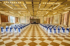 Una gran sala amb files de seients, un sòl amb ratlles de vianera i un escenari al capdamunt.