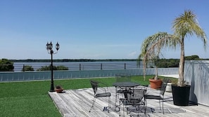 Un patio con una mesa, sillas, una farola y una palmera.