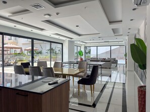 Eine moderne Hotelhalle mit einer Rezeption, einer Sitzgelegenheit und großen Fenstern mit Blick auf die Straße und die umliegenden Gebäude.