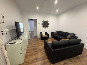 A living room with a TV, two sofas, a clock on the wall, and a white cabinet. - Spacious flat in  centre of the Barrio del Oeste (Salamanca)
