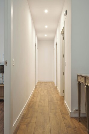A hallway with wooden flooring, white walls, and doors leading to other rooms. - Spacious flat in  centre of the Barrio del Oeste (Salamanca)