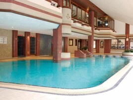 Una piscina interior con varios niveles y una escalera que lleva a la cubierta superior.
